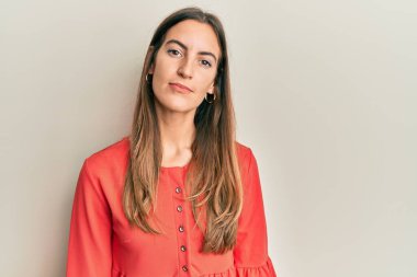 Gündelik kıyafetler giyen genç ve güzel bir kadın. Yüzünde ciddi bir ifadeyle rahatlamış. Basit ve doğal bir şekilde kameraya bakıyorsun.. 