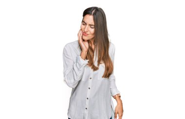 Genç ve güzel bir kadın diş ağrısı ya da diş hastalığından dolayı ağızlarına acı dolu bir ifadeyle dokunuyor. dişçi 