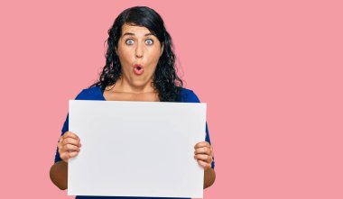 Ayrıca boş afiş taşıyan esmer kadın baş parmağını yana kaldırmış, ağzı açık gülümsüyor. 