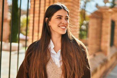 Genç İspanyol kadın gülümseyerek şehirde mutlu mesut dikiliyor..