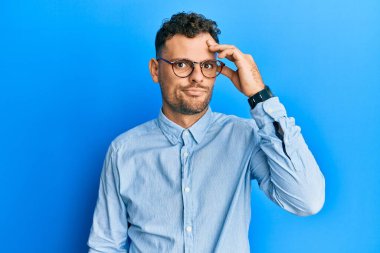 Gündelik kıyafet ve gözlük takan genç İspanyol adam, alnındaki bir sorunla ilgili endişeli ve stresli, gergin ve bunalımda. 