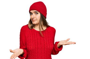 Gündelik kıyafetler giyen, elleri ve kolları havada, kafası karışmış genç İspanyol kadın. şüphe kavramı. 