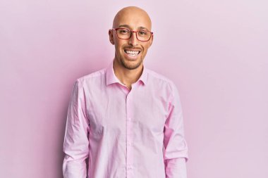 Sakallı, sıradan kıyafetler giyen, mutlu ve havalı bir gülümsemesi olan kel bir adam. şanslı kişi. 