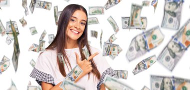 Yüzünde mutlu ve doğal bir ifade olan, elleri ve parmaklarıyla işaret eden, güler yüzlü, gündelik kıyafetler giyen genç İspanyol kadın.