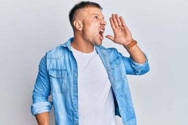 Sıradan bir kot ceket giyen yakışıklı kaslı adam el ele tutuşup bağırıyor ve bağırıyordu. iletişim konsepti. 