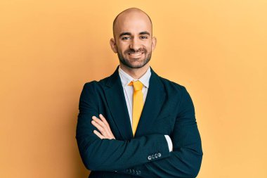 Genç İspanyol bir adam iş elbisesi ve kravat takmış kollarını kavuşturup kameraya bakıyor. pozitif kişi. 