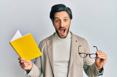 Genç İspanyol bir adam kitap okuyor ve elinde kadehlerle çılgın ve başarıyı kutluyor gözleri açık heyecanla haykırıyor.. 