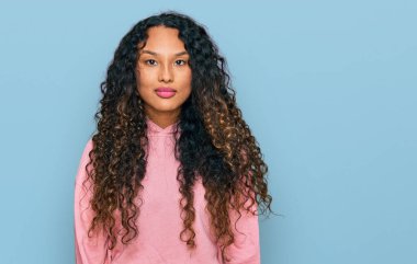 Kıvırcık saçlı, sıradan, yüzünde ciddi bir ifade olan İspanyol bir kadın. Basit ve doğal bir şekilde kameraya bakıyorsun.. 