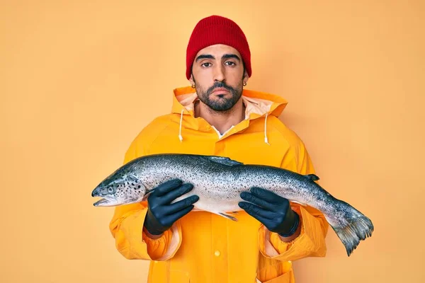 Handsome hispanic man with beard wearing fisherman equipment depressed and worry for distress, crying angry and afraid. sad expression.