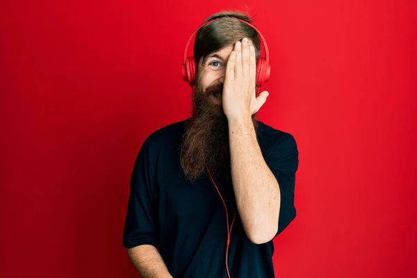 Kızıl Saçlı Uzun Sakallı Müzik Dinleyen Kulaklık Takan Bir Gözünü — Stok fotoğraf