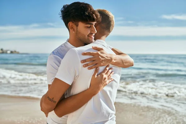 Lovely gay couple on piggyback ride at the beach. Stock Photo