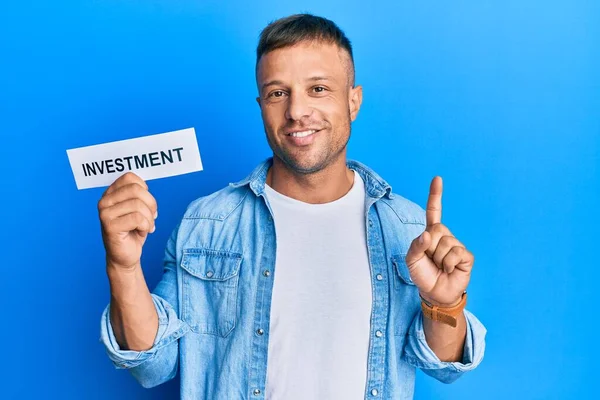 Handsome Muscle Man Holding Investment Word Paper Smiling Idea Question — Stock Photo, Image