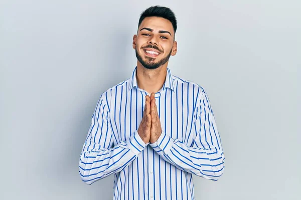 Jovem Hispânico Com Barba Vestindo Camisa Listrada Casual Orando Com — Fotografia de Stock