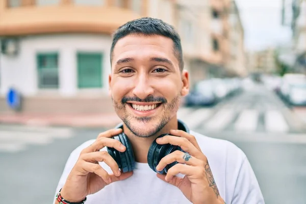 Ung Latinamerikansk Man Ler Glad Lyssnar Musik Med Hörlurar Gatan — Stockfoto