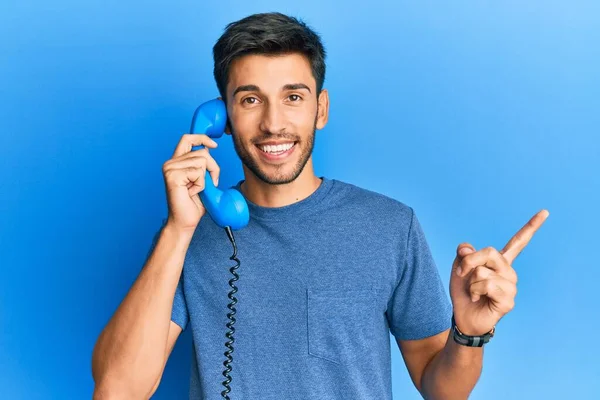 Junger Gutaussehender Mann Telefon Lächelt Glücklich Und Zeigt Mit Der — Stockfoto