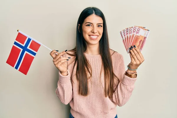 Young Hispanic Woman Holding Norway Flag Krone Banknotes Smiling Happy — Stock Photo, Image