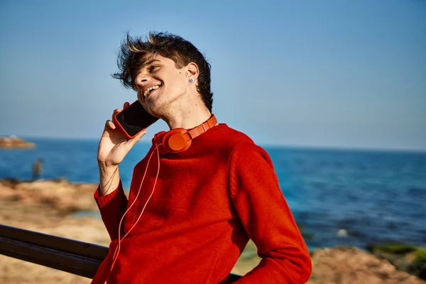 Ung Latinamerikansk Man Ler Glad Pratar Smartphone Stranden — Stockfoto