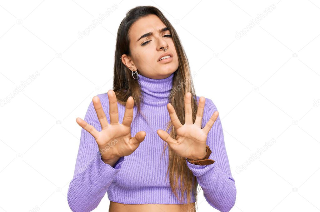 Young hispanic woman wearing casual clothes moving away hands palms showing refusal and denial with afraid and disgusting expression. stop and forbidden. 