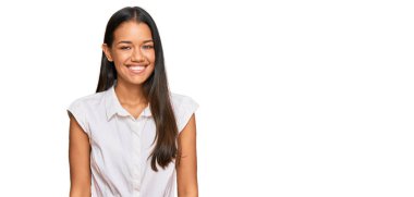 Güzel İspanyol kadın gündelik kıyafetler giyiyor. Pozitif ve mutlu görünüyor. Kendine güvenen bir gülümsemeyle dişlerini gösteriyor. 