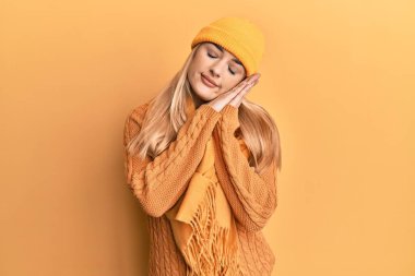 Kafkasyalı genç bir kadın yün kazak ve şapka giyer, uyur, uyur, hayal kurar, el ele poz verir ve gözleri kapalı gülümserdi.. 