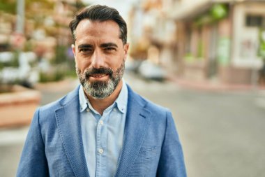 Orta yaşlı işadamı şehirde mutlu mesut dikilirken.