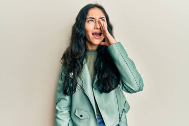 Diş teli takan, yeşil deri ceketli, bağıran ve ağızları açık bağıran İspanyol bir genç kız. iletişim konsepti. 