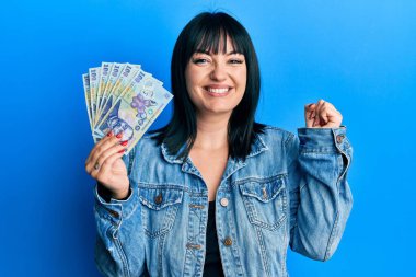 Genç İspanyol kadın elinde 100 Romen Ley banknotuyla gururla bağırıyor zaferi ve başarıyı kutluyor. 