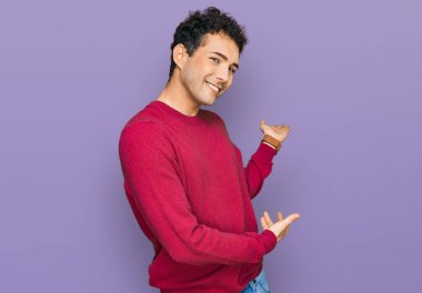 Gündelik kıyafetler giyen genç yakışıklı adam gülümseyerek içeri girmeye davet ediyor. 