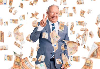 Kıdemli yakışıklı, gri saçlı, zarif takım elbiseli, kendini beğenmiş, mutlu bir şekilde gülümserken iki numaralı parmaklarıyla onu işaret eden adam..