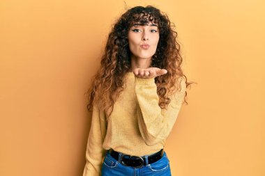 Gündelik giysiler giymiş genç İspanyol kız kameraya bakıyor. Canlı yayında öpüşüyorlar. Güzel ve seksiler. aşk ifadesi. 