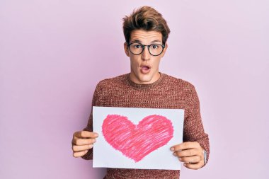 Kalbi olan yakışıklı beyaz adam şaşırmış ve şaşırmış bir ifadeyle korku ve heyecan dolu bir yüzle şoka girmiş.. 