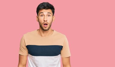 Gündelik kıyafetler giyen genç yakışıklı adam şaşkınlık ve şaşkınlık dolu bir ifade, korku ve heyecan dolu bir yüz ile şoka uğradı.. 