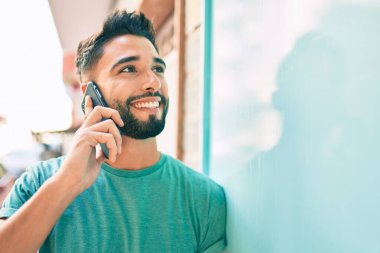 Şehirdeki akıllı telefondan konuşan, ciddi bir suratı olan genç bir Arap..