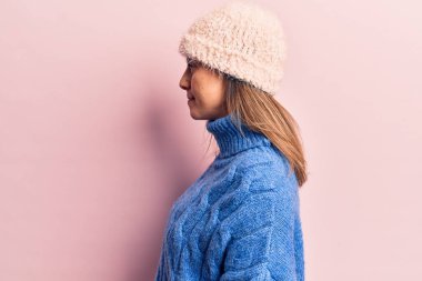 Kış kıyafetleri giyen genç ve güzel bir kadın. Taraf arıyor, rahat poz veriyor. Kendine güvenen bir gülümsemesi olan doğal bir yüz.. 