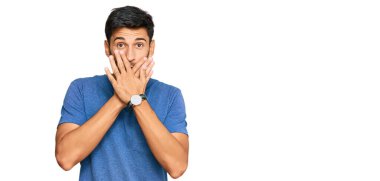 Gündelik giysiler giyen genç yakışıklı adam yanlışlıkla elleri ile ağzını kapatırken şok oldu. gizli kavram. 