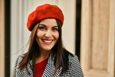 Genç İspanyol kadın gülümseyerek şehirde mutlu mesut dikiliyor..