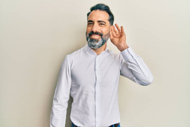 Orta yaşlı, sakallı, gri saçlı, sıradan beyaz tişörtlü, sırıtan, kulağına fısıldayan, dedikoduları ve dedikoduları dinleyen bir adam. Sağırlık kavramı. 