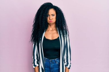 Orta yaşlı Afro-Amerikan kadın günlük kıyafetler giyip komik suratlı yanakları şişiriyor. Havayla şişmiş ağız, çılgın bir ifade.. 