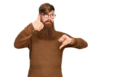 Genç İrlandalı kızıl saçlı, günlük kıyafetler ve gözlük takan, baş parmak kaldıran, anlaşmazlık ve anlaşma ifadesi takınan bir adam. çılgın çatışma 