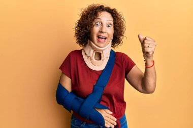 Güzel orta yaşlı olgun bir kadın boyun tasması takıyor ve kolu askıda gururla bağırıyor zaferi ve başarıyı kutluyor. Kollarını kaldırarak heyecanlanıyor. 