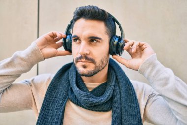 Gevşek yüzlü, şehirde kulaklık takıp müzik dinleyen genç bir İspanyol..