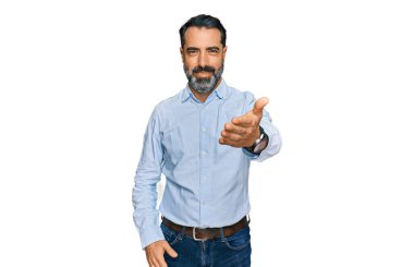 Middle aged man with beard wearing business shirt smiling cheerful offering palm hand giving assistance and acceptance.  clipart