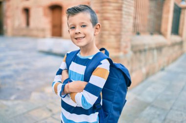 Sevimli beyaz bir öğrenci şehirde mutlu bir şekilde gülümsüyor..