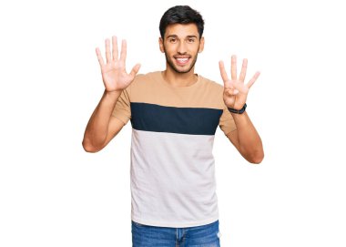 Gündelik kıyafetler giyen genç ve yakışıklı bir adam dokuz numarayı gösterip işaret ederken kendinden emin ve mutlu bir şekilde gülümsüyor.. 