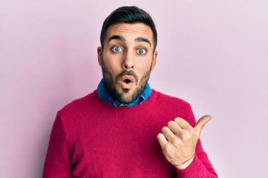 Gündelik giysiler giyen genç İspanyol adam elleri yana doğru işaret ederek şaşırdı, ağzı açık hayret içinde kaldı.. 