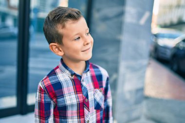 Sevimli beyaz çocuk, şehirde mutlu mesut dikiliyor..