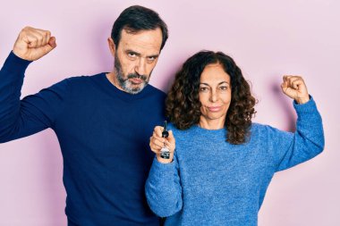 Orta yaşlı bir çift İspanyol kadın ve yeni evinin anahtarlarını tutan bir adam güçlü kol kası gösteren, kendinden emin ve gururlu bir adam. 