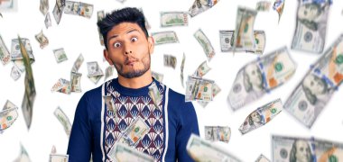 Yakışıklı Latin Amerikalı genç adam, günlük kışlık süveter giyiyor, dudaklarıyla balık suratı yapıyor, çılgınca ve komik bir jest. Komik ifade.