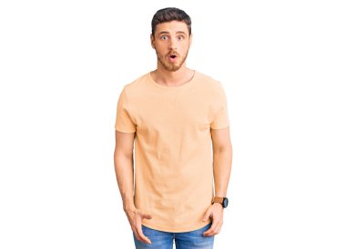 Sarı bir tişört giyen yakışıklı genç adam, korku, korku ve heyecanlı bir yüz ifadesiyle korkmuş ve şok olmuştu.. 