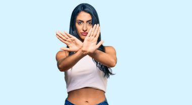 Güzel İspanyol kadın gündelik kıyafetler giyiyor. Reddedilmiş yüz ifadesi. Kollarını kavuşturuyor. 